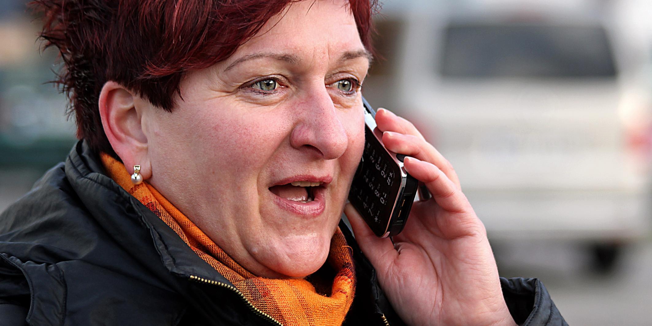 Frau mit rotem Haar telefoniert draußen, trägt Schal und Jacke. (c) Peter Weidemann in Pfarrbriefservice Frau mit rotem Haar telefoniert draußen, trägt Schal und Jacke.