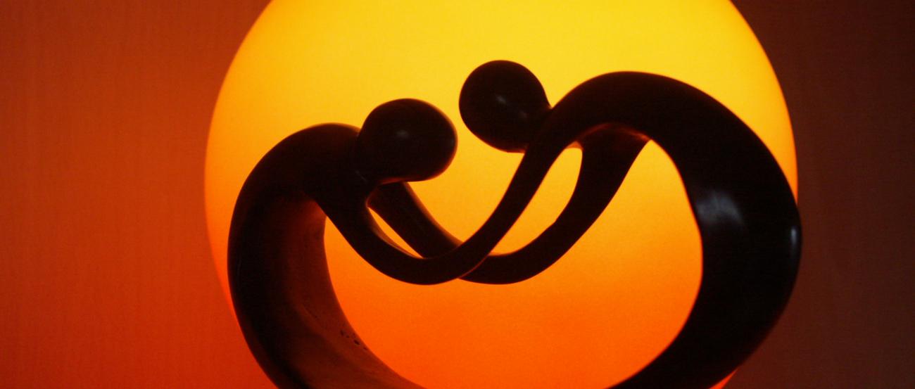 eine Tischlampe aus einer Skulptur von zwei Figuren in gebeugter Haltung, die sich an den Händen halten