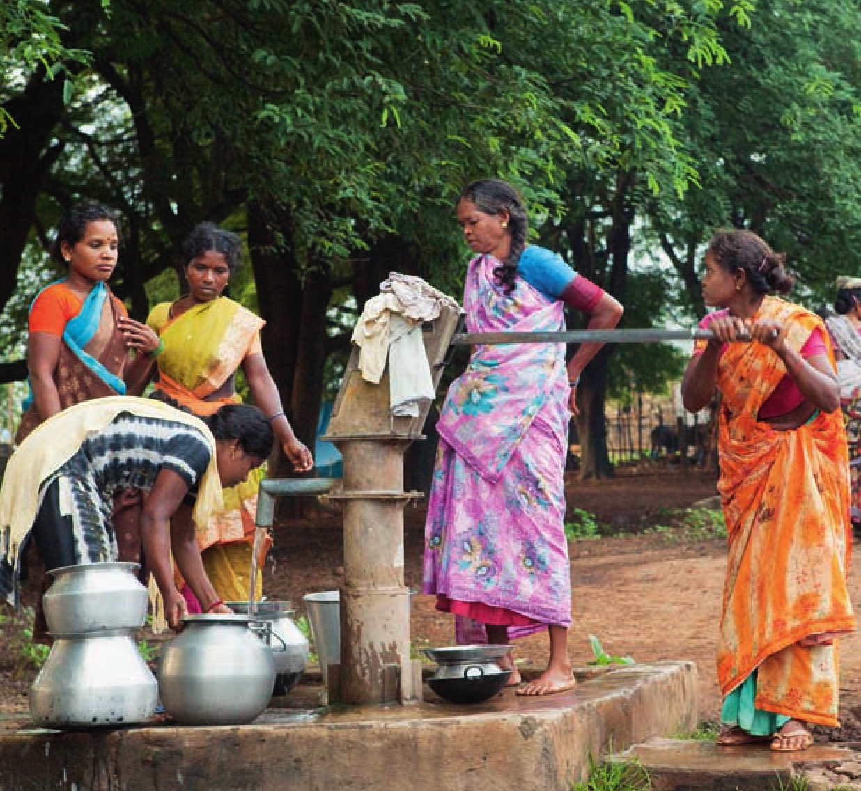 4 Frauen in bunten Gewändern beim Wasserholen am Brunnen