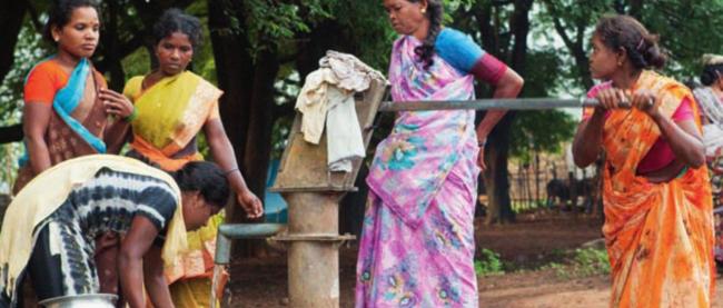 4 Frauen in bunten Gewändern beim Wasserholen am Brunnen