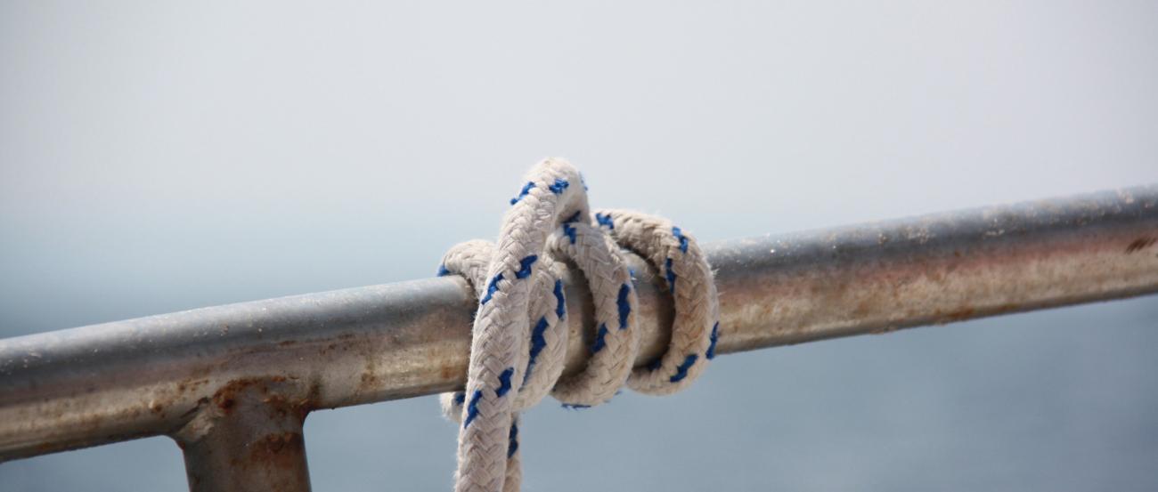 ein starkes Seil ist mehrmals um ein Geländer gewickelt