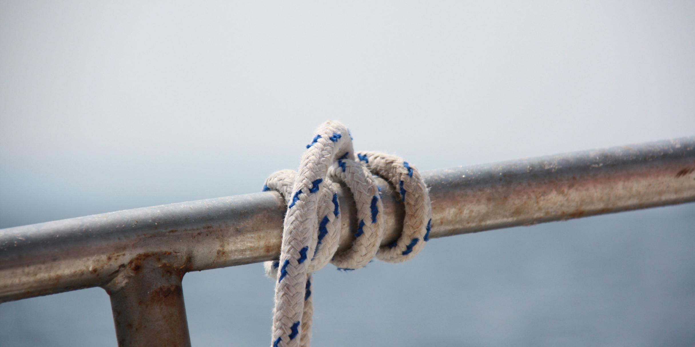 ein starkes Seil ist mehrmals um ein Geländer gewickelt