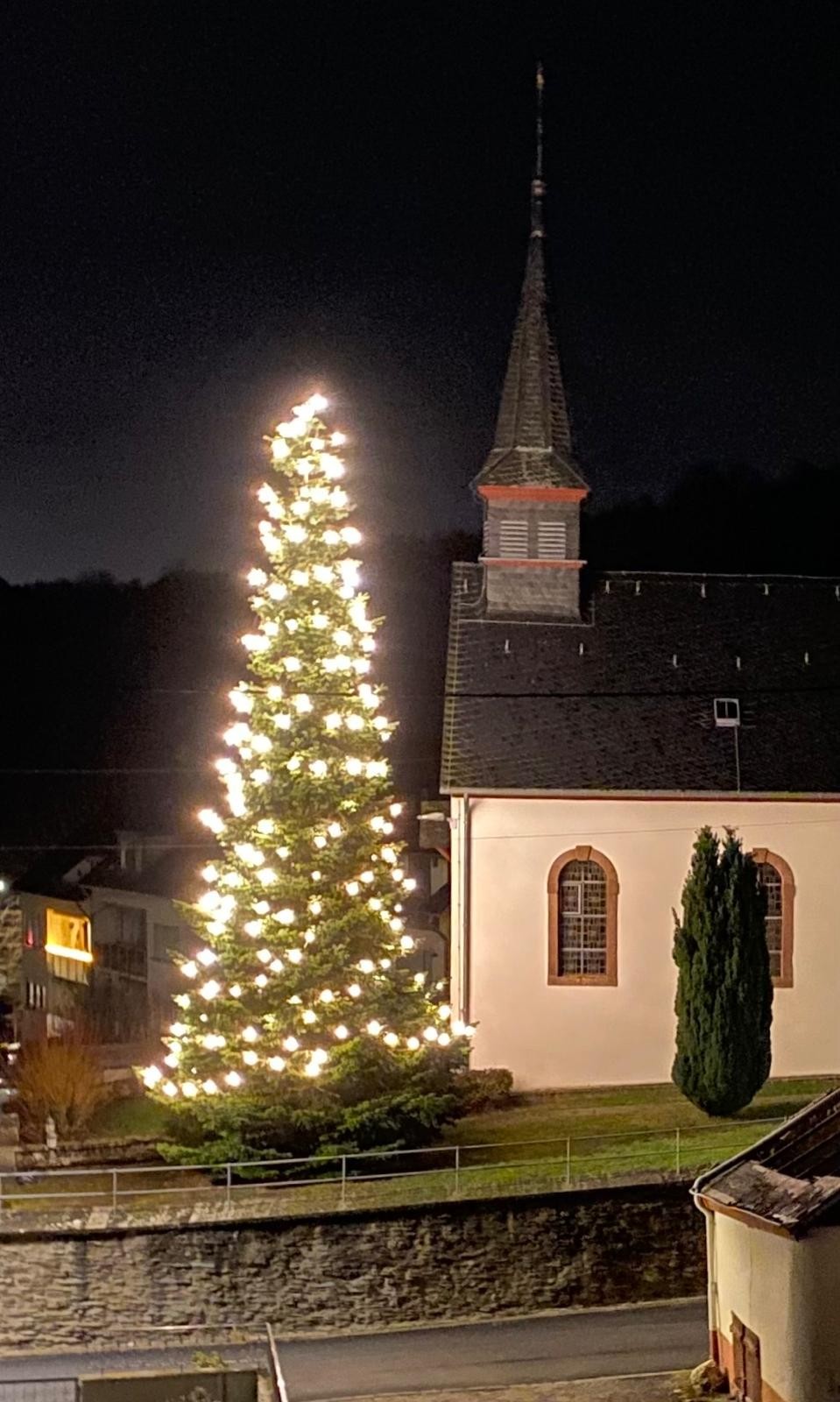 eine 12 Meter hohe Tanne mit Lichtern geschmückt neben der Kapelle St. Luzia in Filsch