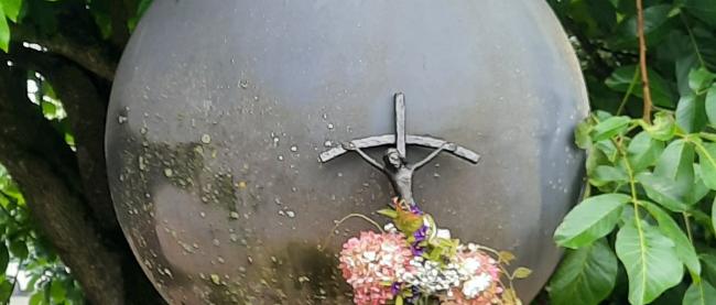 geschmücktes Vortragekreuz auf dem Weg nach Klausen vor einem Kunstwerk