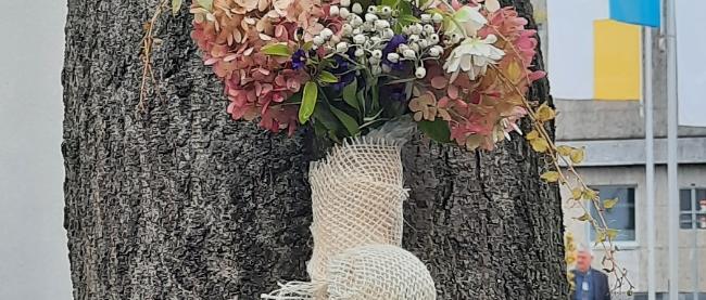 geschmücktes Vortragekreuz auf dem Weg nach Klausen angelehnt an einen Baum