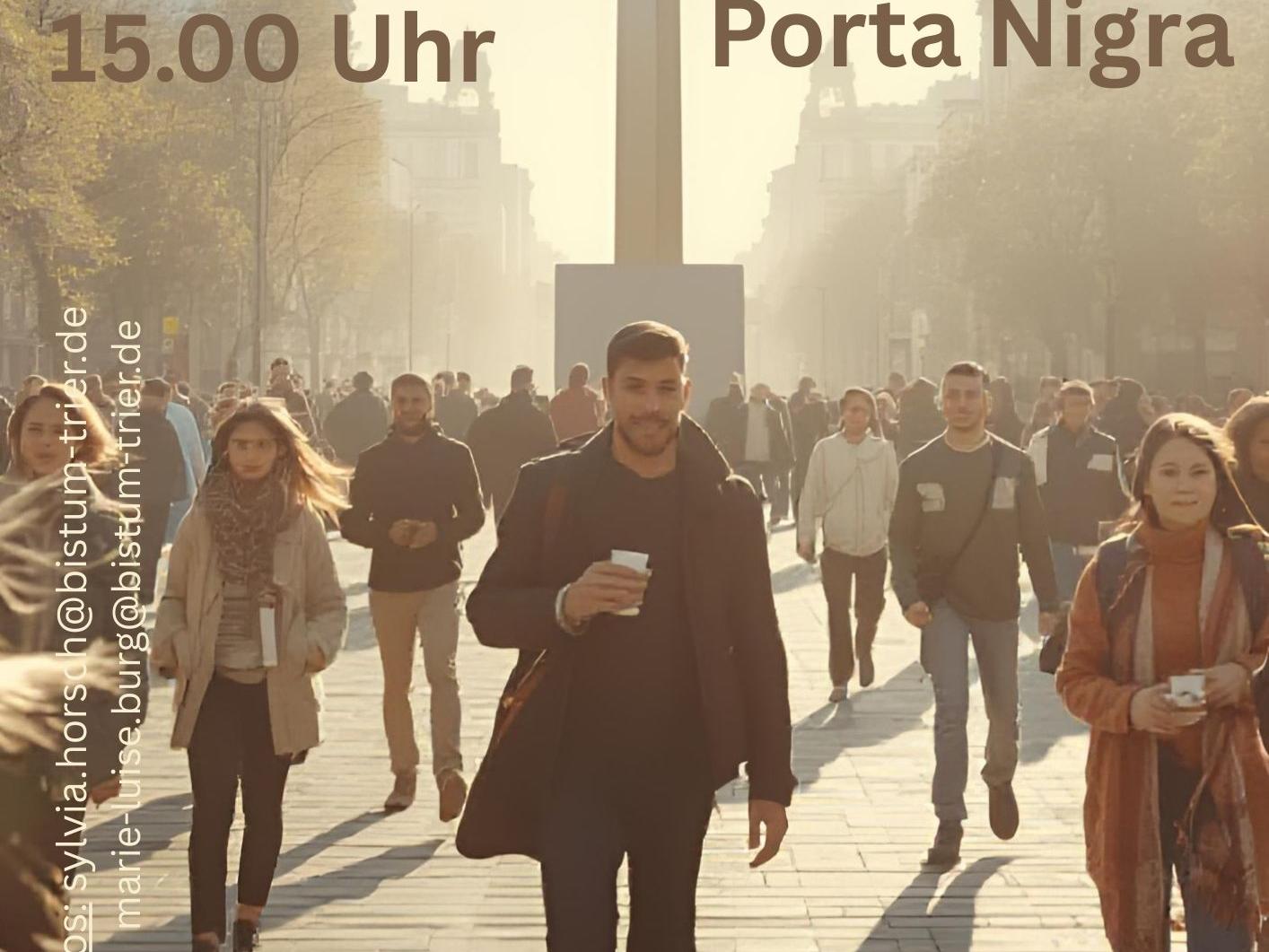 Menschen unterwegs in einer Innenstadt im Bildmittelpunkt ein großes Kreuz, Aufschrift Kreuzweg in der City