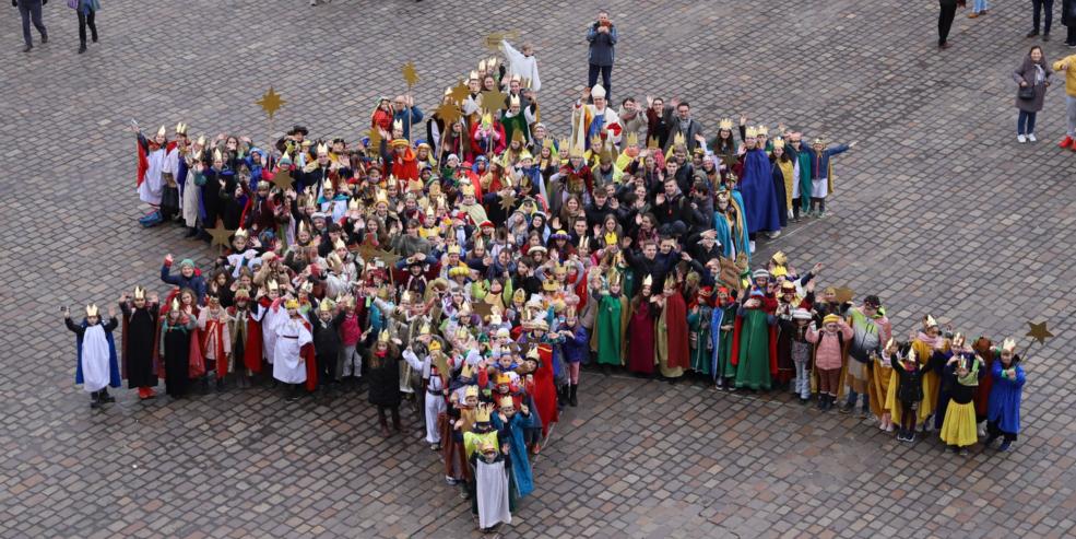 Sternsinger und Sternsingerinnen bilden gemeinsam einen großen Stern
