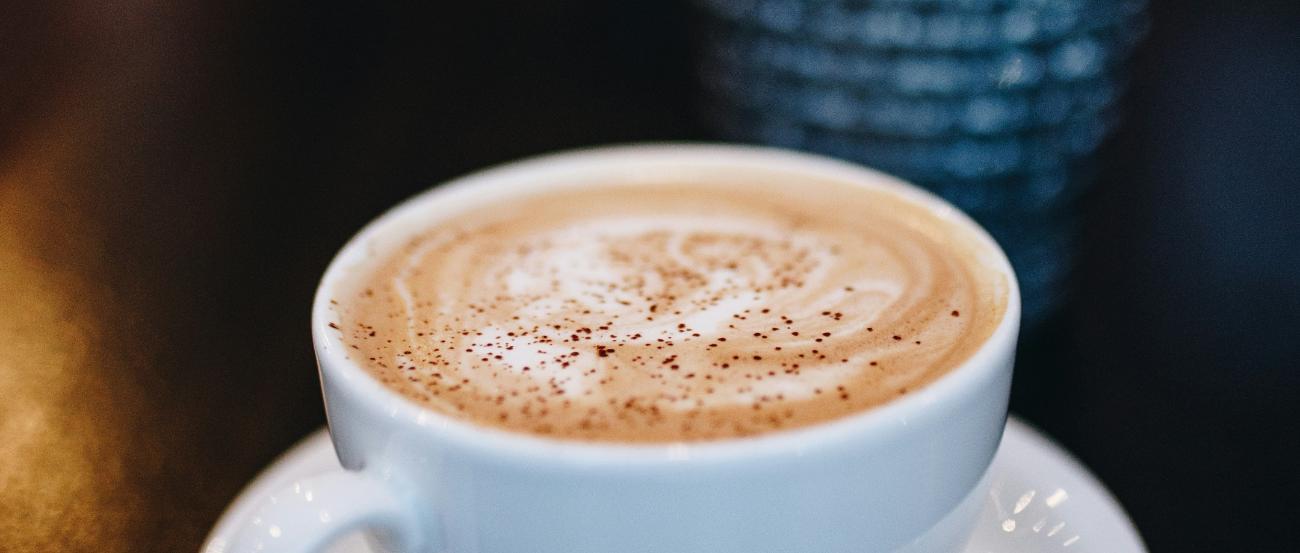 eine weiße Tasse mit cremigen Milchkaffee