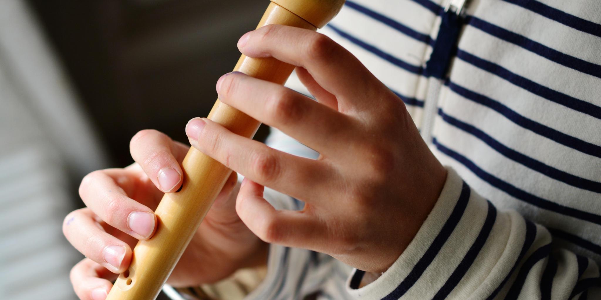 Kind spielt Blockflöte