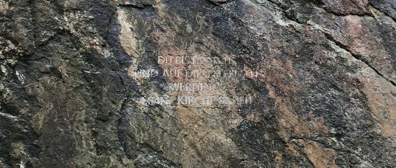 Ein Fels mit der Schrift 'Auf dich werde ich meine Kirche bauen'