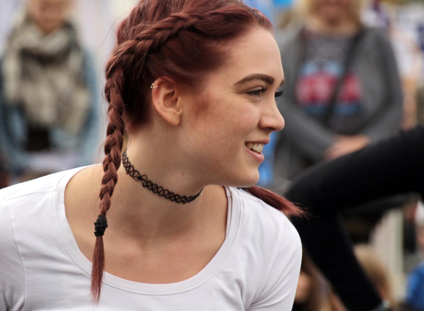 eine junge Frau mit roten Haaren, die zu zwei Zöpfen gepflochten sind