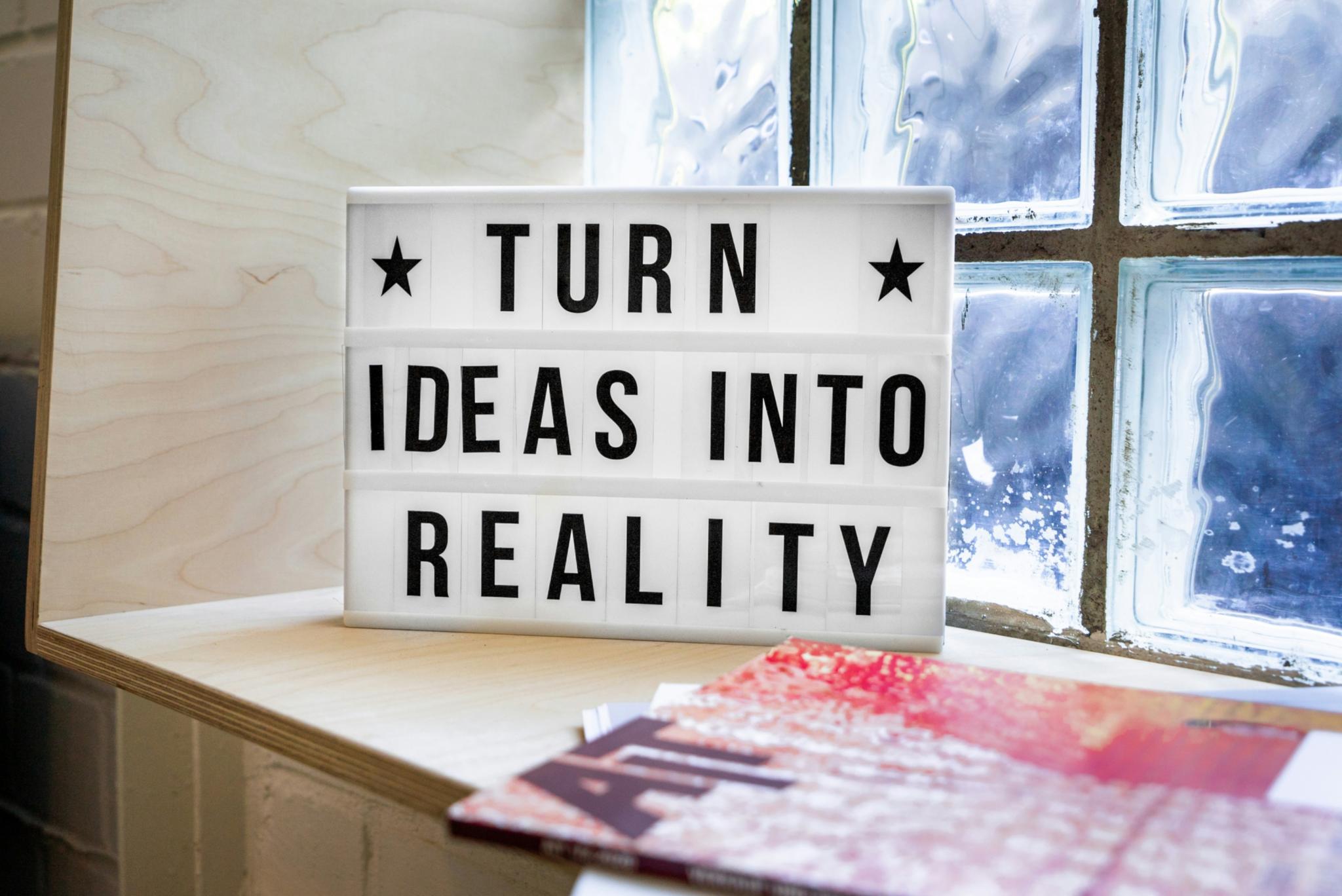 auf einer Fensterband steht das Schild aus Glas Turn ideas into reality