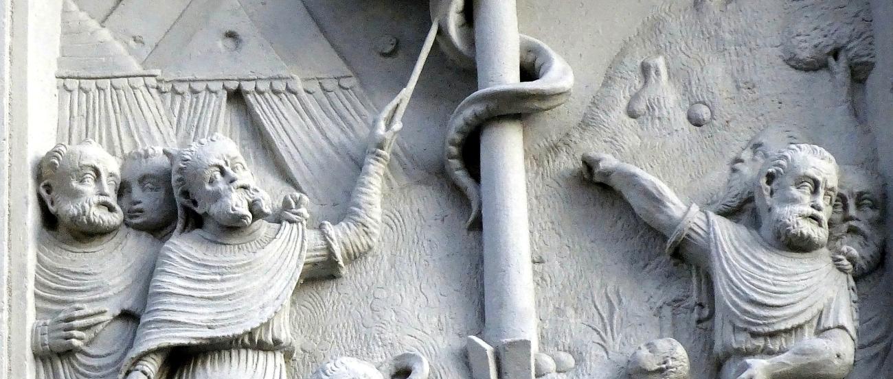 Das Bild zeigt ein Relief von der Schlange, die Moses in der Wüste erhöht hat