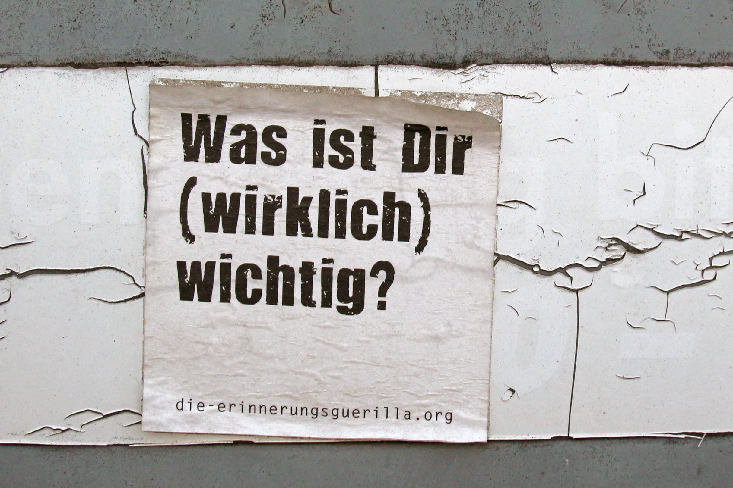 Weiße Wand mit Plakat: Was ist dir (wirklich) wichtig?